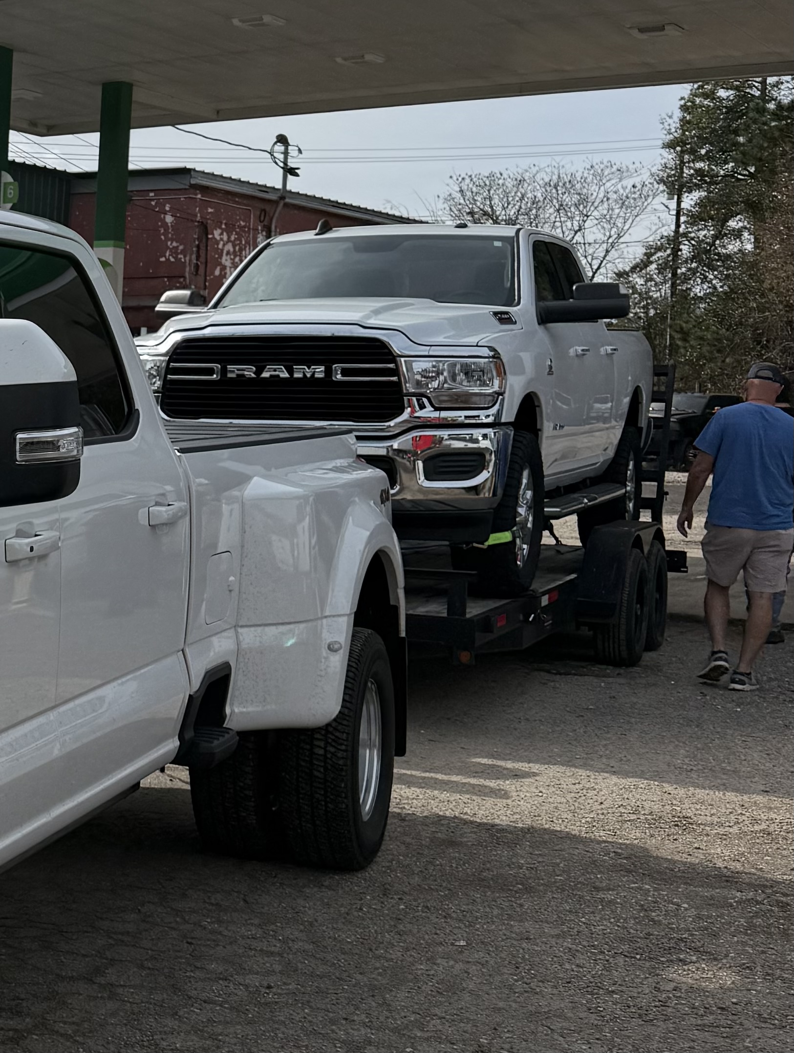 White RAM truck being transported on a flatbed trailer
